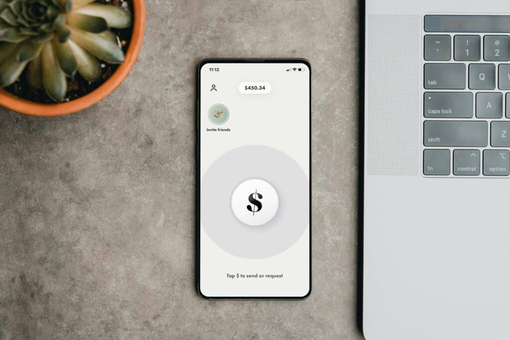how long does a bank transfer take, phone payment app next to laptop photo